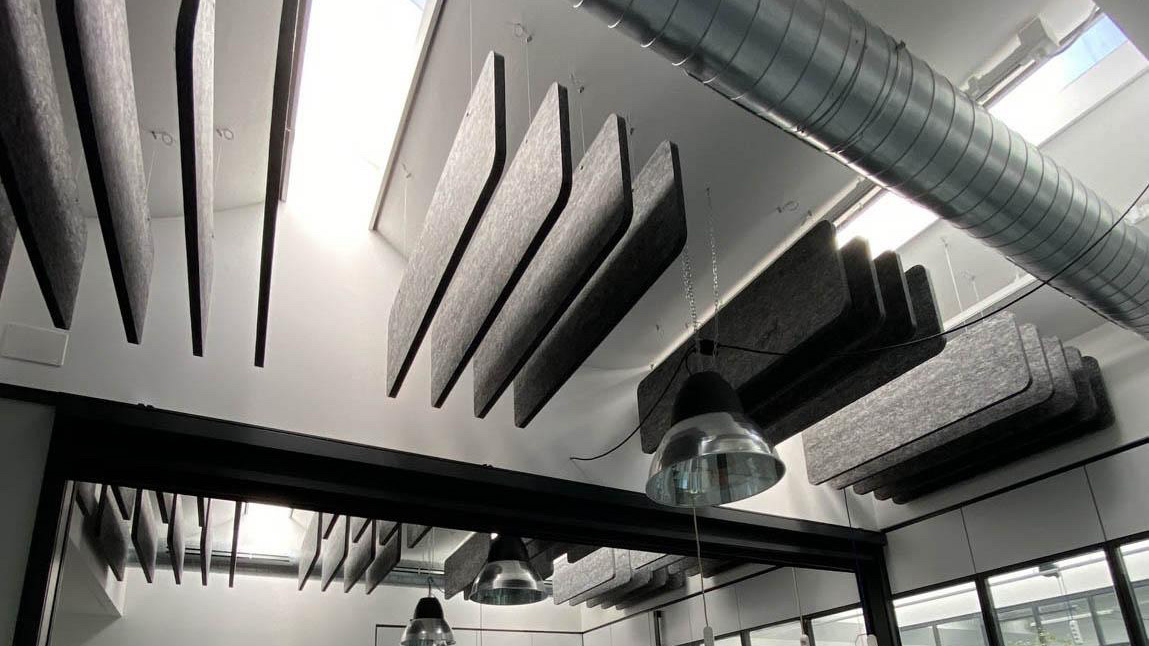 Suspended acoustic absorbers used to reduce reverberation and control mid- to high-frequency reflections in open architectural spaces.